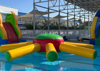 Hinchables acuáticos con toboganes y juegos en piscina.