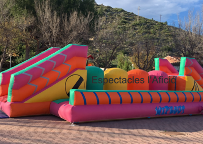 Inflable Wipeout con estructura colorida y rampas.