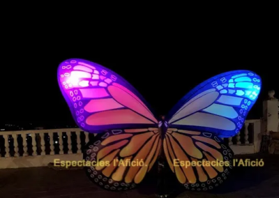 Alas de mariposa iluminadas en un espectáculo nocturno.