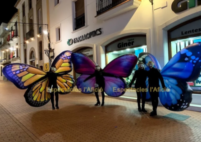 Artistas con alas de mariposa de colores.