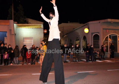 Animador en zancos durante un desfile nocturno.