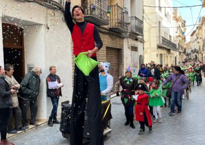 Animador en zancos lanzando confeti durante un desfile.