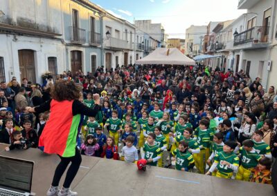 Animador con niños disfrazados en evento callejero.