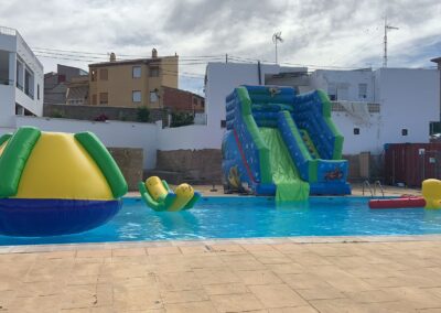 Piscina con atracciones hinchables y tobogán.