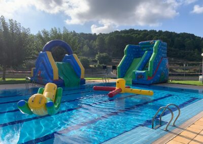 Piscina con toboganes hinchables y atracciones flotantes.