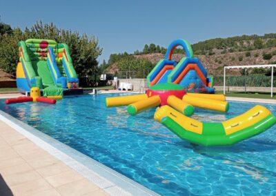 Piscina con toboganes hinchables y juegos acuáticos.