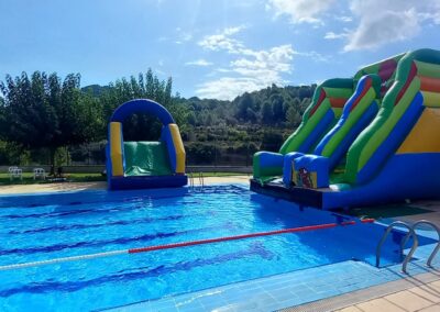 Toboganes hinchables en piscina exterior.