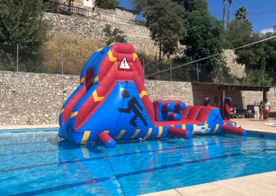 Tobogán hinchable en la piscina con obstáculos.