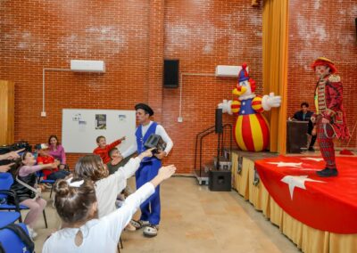 Payaso interactuando con niños durante un espectáculo.