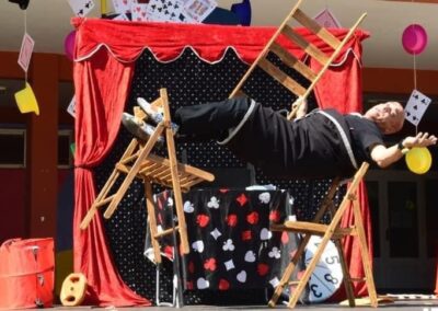 Artista realizando un truco de equilibrio con sillas.