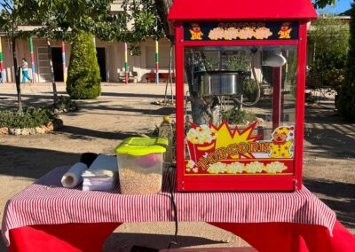 Máquina de palomitas sobre una mesa con accesorios.