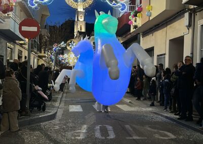 Caballo hinchable luminoso en pasacalles nocturno.