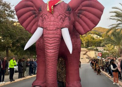 Elefante hinchable gigante en desfile temático al aire libre.