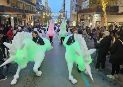 Unicornios hinchables luminosos en desfile callejero.