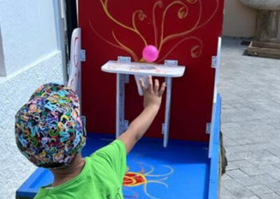 Niño jugando a lanzar una pelota en un juego de feria.